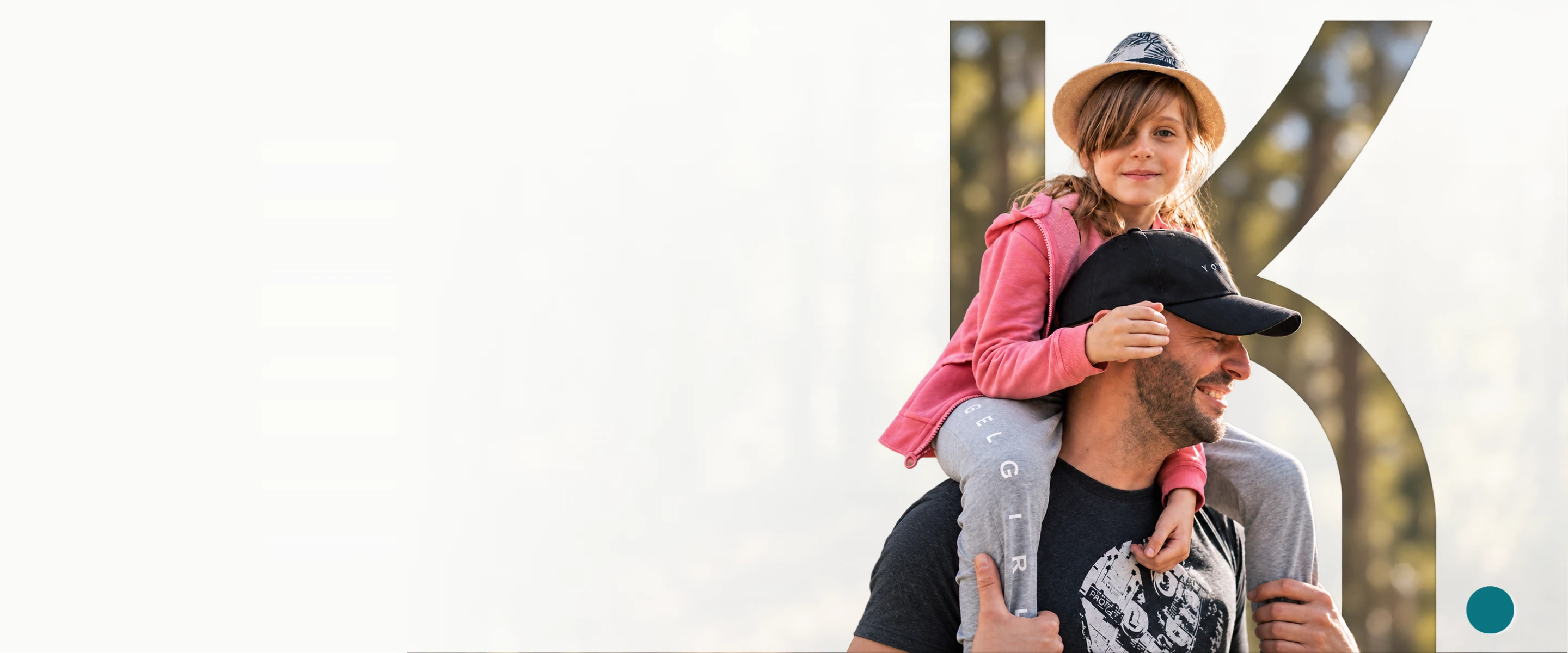 A father carrying his daughter on his shoulders, smiling outdoors